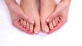 Closeup photo of a beautiful female feet with red pedicure on white Royalty Free Stock Photo