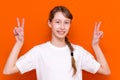 Closeup photo of beautiful little braided hair girl arms showing v-sign symbol hi friends good mood wear white t-shirt