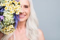 Closeup photo of beautiful retired woman hide half face big bunch wild flowers coquettish isolated grey color background