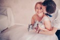 Closeup photo of beautiful smiling bride with rabbits in her hands kissed by the groom in warm colors