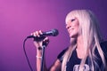 Closeup photo of blond haired nice lady singer on party in night club with microphone karaoke wear black t-shirt on pink Royalty Free Stock Photo