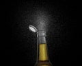 Closeup photo of an Brown beer bottle splashing beer drops on a black background. Beer cap flying on top of the bottle