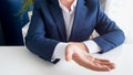 Closeup image of businessman sitting behind office desk stretching hand and asking for money Royalty Free Stock Photo
