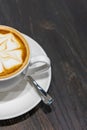 Closeup photo of cappuccino latte art coffee on rustic background Royalty Free Stock Photo