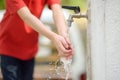 Closeup photo of child washing hands in a city fountain. Little boy drinking clean water from a street pump Royalty Free Stock Photo