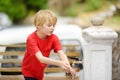 Closeup photo of child washing hands in a city fountain. Little boy drinking clean water from a street pump Royalty Free Stock Photo