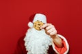 Closeup photo of Christmas cookies in Santa Claus hands isolated on red background. Christmas concept. Background