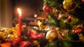 Closeup image of decorated Christmas tree branch against burning candle on traditional wreath Royalty Free Stock Photo