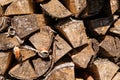 Closeup photo of dry logs stacked in rows, illuminated by sunlight. Pattern and structure of the tree. Decorative wooden layout.