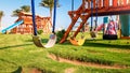 Closeup image of empty swings on the children playground at bright sunny day. Nobody playing in park Royalty Free Stock Photo