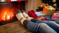 Closeup image of family in woolen socks lying next to Christmas tree and warming by the fireplace Royalty Free Stock Photo