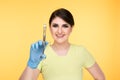 Closeup photo of female dentist holding oral syringe isolated over the yellow backgrownd.