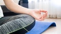 Closeup photo of folded fingers of young woman meditating at home