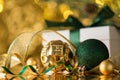 Closeup photo of gold and green christmas tree decorations ornaments balls serpentine ribbon white giftbox with bow and fir branch Royalty Free Stock Photo