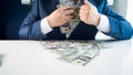 Closeup photo of greedy covetous businesman filling his pockets with stacks of money Royalty Free Stock Photo