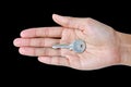 Closeup photo of hand holding keys, isolated on black background Royalty Free Stock Photo