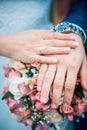 Closeup photo of hands of bride and groom with wedding rings and bouquet. Royalty Free Stock Photo