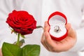 Closeup photo of a handsome man with a red rose and wedding ring Royalty Free Stock Photo