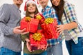 Closeup photo of happy friends in santa hats holding christmas presents Royalty Free Stock Photo