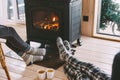 Closeup photo of human feet in warm woolen socks over fire place Royalty Free Stock Photo