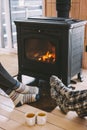 Closeup photo of human feet in warm woolen socks over fire place Royalty Free Stock Photo