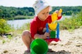 Closeup photo of a little girl. A child plays with the sand on the beach.