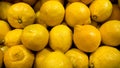 Closeup image of lots of organic lemons lying on store counter. Closeup texture or pattern of fresh ripe fruits