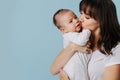 Loving mother hugs baby and kissing, holding him in her arms Royalty Free Stock Photo