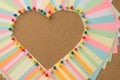 Closeup photo of many colorful notepaper making heart shape attached to the wooden board with pins Royalty Free Stock Photo