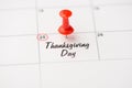 Closeup photo of mark on calendar at twenty-fifth inscription thanksgiving day with red pushpin