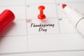 Closeup photo of mark on calendar at twenty-fifth inscription thanksgiving day with red pushpin and red felt pen