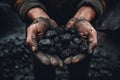 Closeup photo of Miner& x27;s hands holding black coal