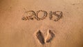 Closeup photo of 2019 New Year numbers and footrpints on wet sand at ocean beach. Concept of New Year, Christmas and Royalty Free Stock Photo