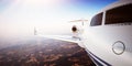 Closeup Photo Pilot Cabin White Luxury Generic Design Private Jet Airplane Flying Blue Sky sunset.Uninhabited Desert Royalty Free Stock Photo