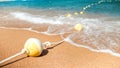 Closeup image of plastic floating buoys connected in line by rope lying on the sea beach. Perfect shot to illustrate Royalty Free Stock Photo