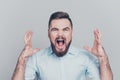 Closeup photo portrait of aggressive crazy mad bad furious man gesturing with hands isolated on grey background Royalty Free Stock Photo