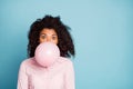 Closeup photo of pretty wavy dark skin lady holding big air balloon in mouth closing half crazy facial expression Royalty Free Stock Photo