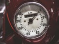 Closeup photo of a round speedometer of an old red motorcycle