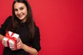 Closeup photo shot of beautiful happy smiling brunette female teenager isolated over red background wall wearing black Royalty Free Stock Photo