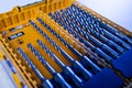 Closeup photo shot of yellow and transparent kit box with drills for drilling holes on a white table and isolated on Royalty Free Stock Photo