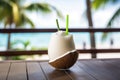 Closeup Photo Showcases Fresh, Cold Coconut Juice Cocktail With Straw Resting On Bar Counter Against
