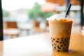 Closeup Photo Showcases Tantalizing Taiwan Milk Bubble Tea, Also Known As Boba, In Plastic Cup On Wo