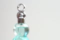 The top lid cover part of a light blue green perfume bottle