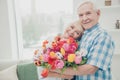 Closeup photo of two adorable aged people cute pair anniversary holiday surprise big red tulips bunch flat indoors