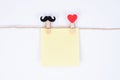 Closeup photo of two clothespins symbolizing a human pair holding sheet of paper white background