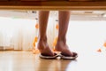 Closeup image from under the bed of female feet wearing slippers Royalty Free Stock Photo