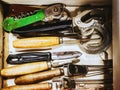 Closeup photo of vintage kitchen appliances, knives for peeling potato whisk for whipping and openers lying at the