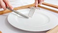 Closeup photo of woman eating medicine pill with knife and fork. Concept of dieting, weight loss and medicine