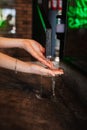 Closeup photo of woman washing hands in cafe. water flows in the hands. water from pipes