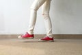 Closeup Photo of From Woman Wearing Red Sneakers On The Concrete Floor Background